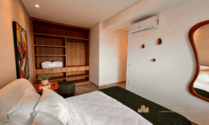 Quarto de casal com cabeceira premium e persiana blackout integrada automatizada na janela.