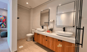Quarta suíte residencial decorada com duas camas de solteiro e painel de madeira terracota.