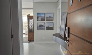 Sala de estar bem iluminada com sofá, TV e decoração moderna.