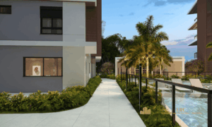 Alameda de acesso com projeto paisagístico e palmeiras direcionando para as áreas comuns do Villa Maggiore João Paulo.