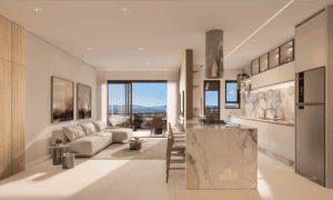Interior da cobertura com living, cozinha americana com ilha em mármore e varanda com vista para o mar.