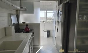 Cozinha planejada com armários sob medida e área de serviço integrada.