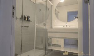 Banheiro completo com armário planejado, box blindex e espelho.