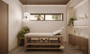 Sala de massagem reservada com maca de madeira, lavatório e decoração relaxante.