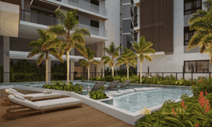 Piscina infantil rasa com prainha, cercada por segurança e áreas de sombra.