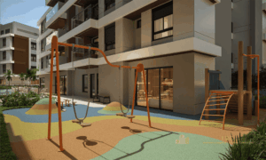 Playground infantil externo com balanços, brinquedos de madeira e piso emborrachado anti-impacto.